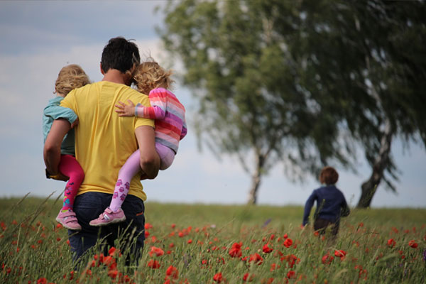 Family walking through a field of red flowers